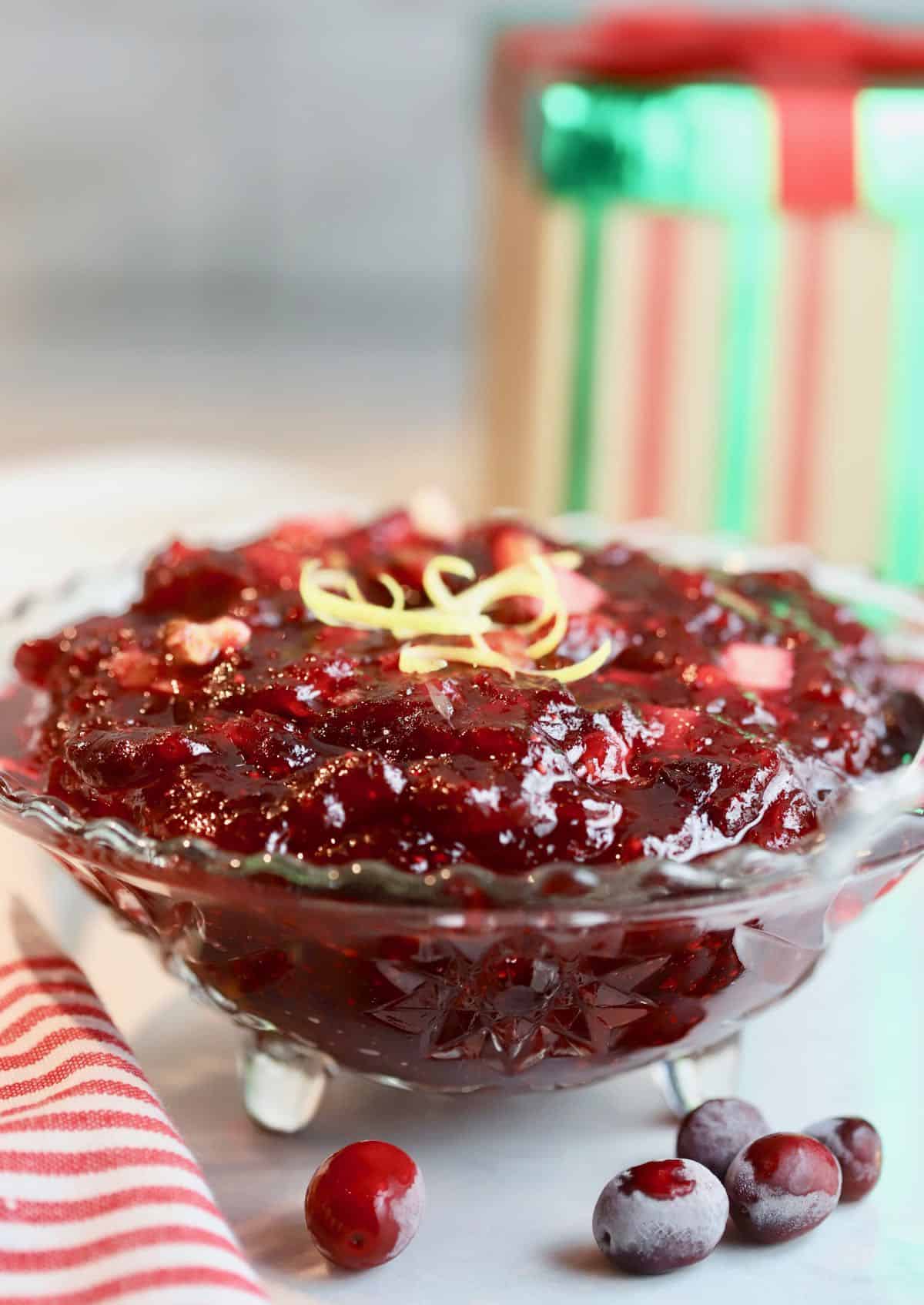 A cut glass bowl full of cranberry sauce.