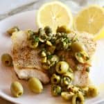 A grouper fillet topped with chopped olives and capers.