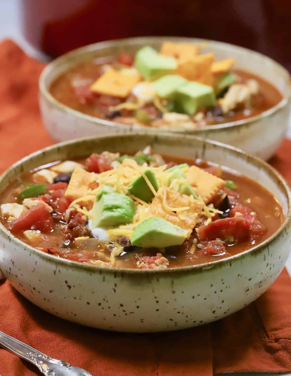 A bowl of turkey chili topped with sour cream and cheese. 