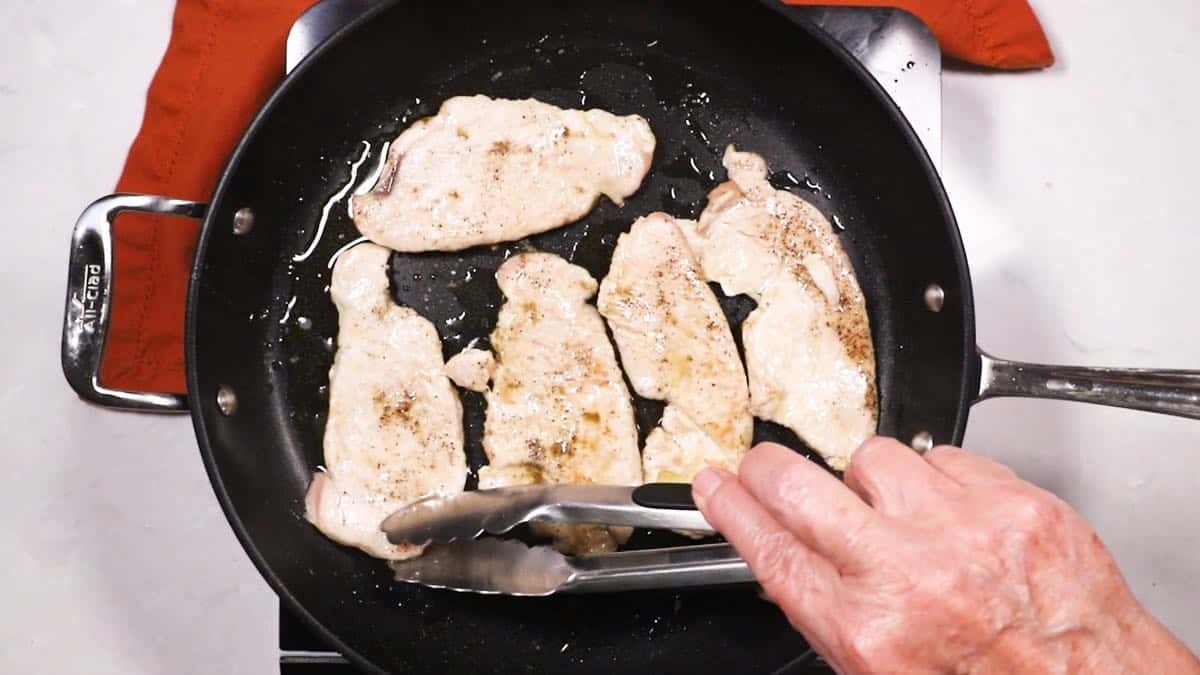 Cooking turkey cutlets in a skillet.