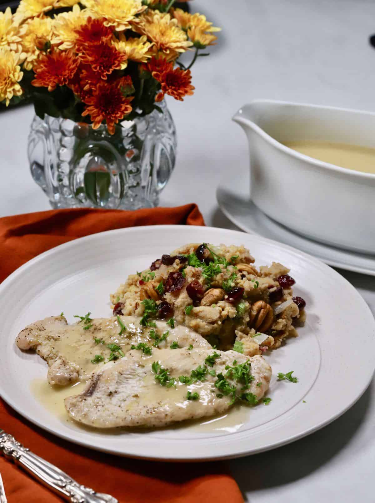 Turkey cutlets, gravy and dressing on a white plate. 