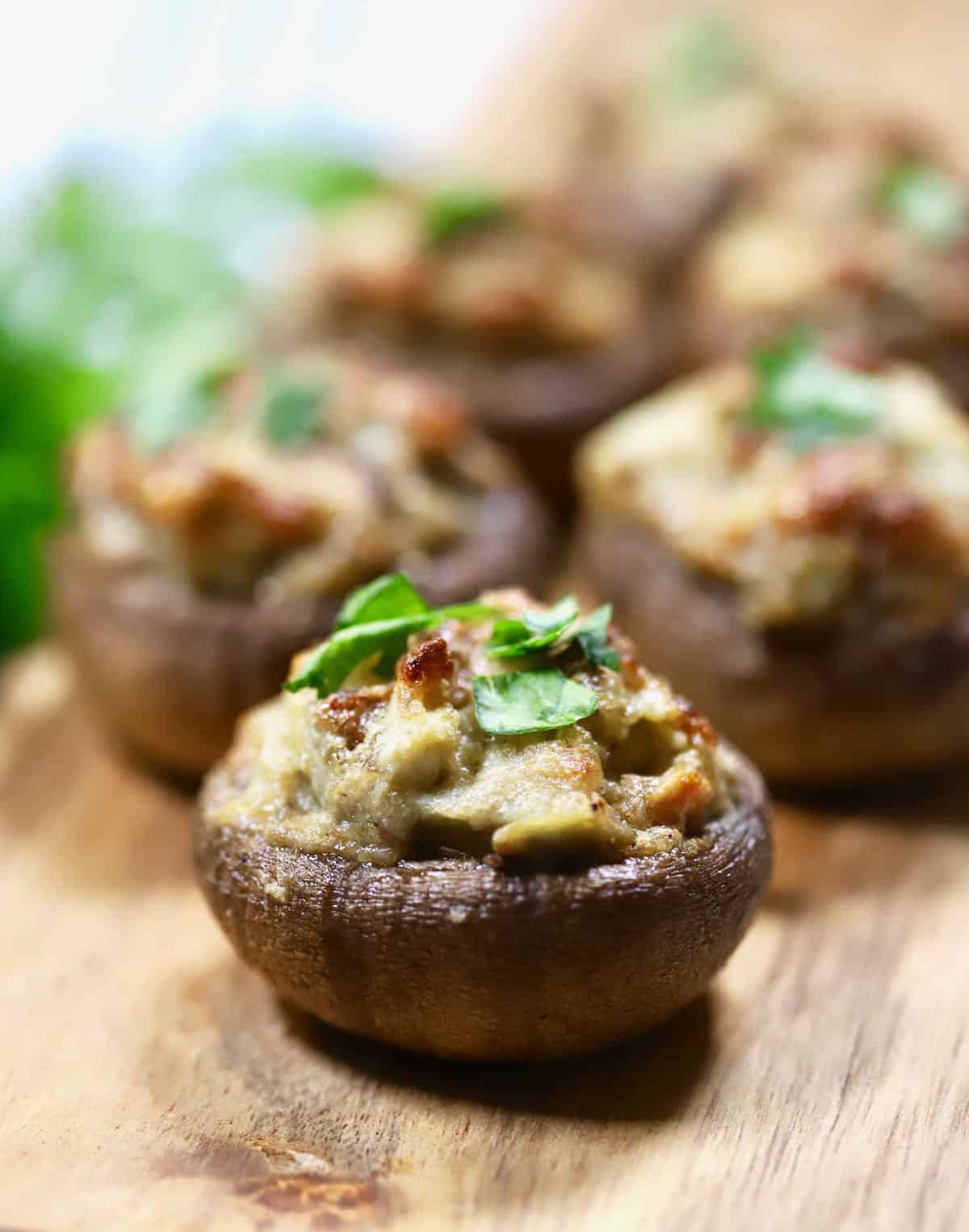 Artichoke stuffed mushroom on a cutting board. 