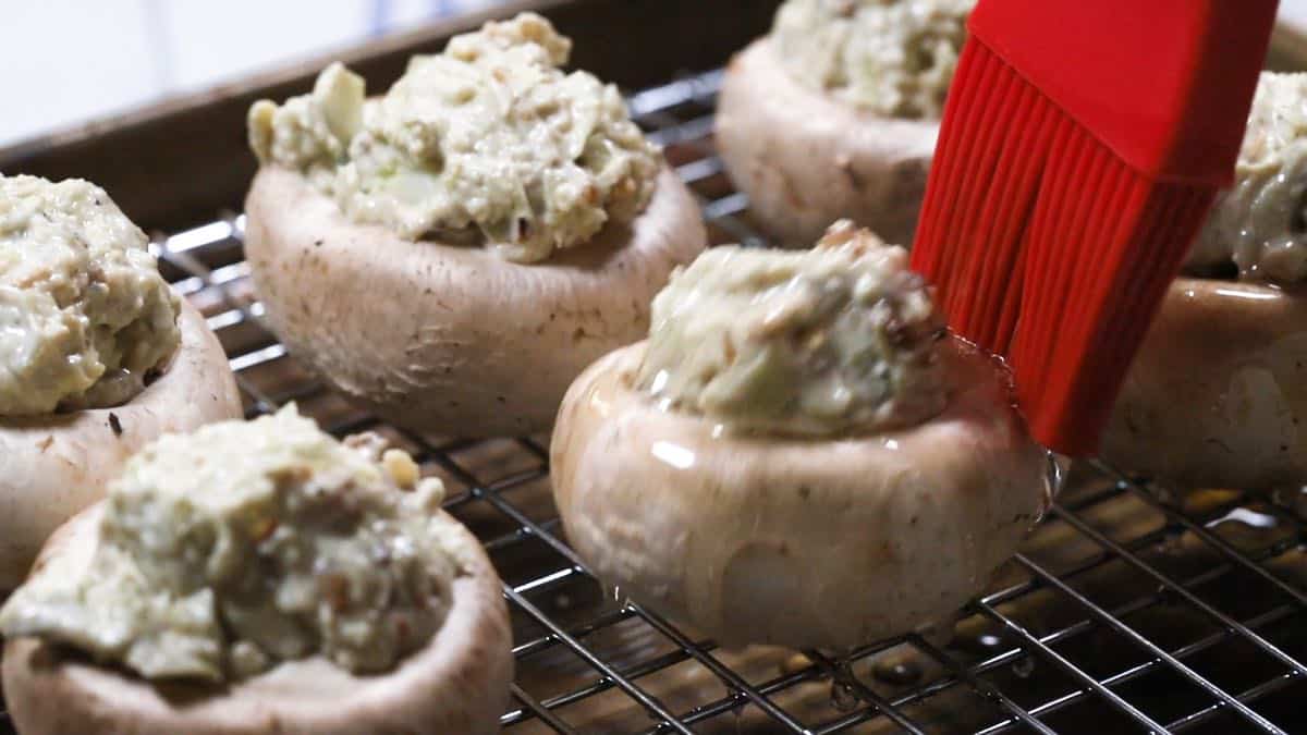 Brushing olive oil over mushrooms. 