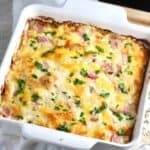Au gratin potatoes and ham in a white baking dish.