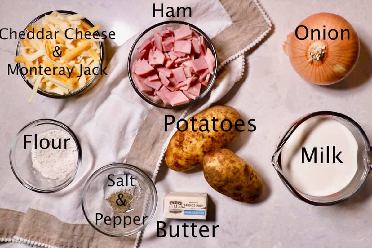 Ham, potatoes, milk, and flour on a cutting board. 