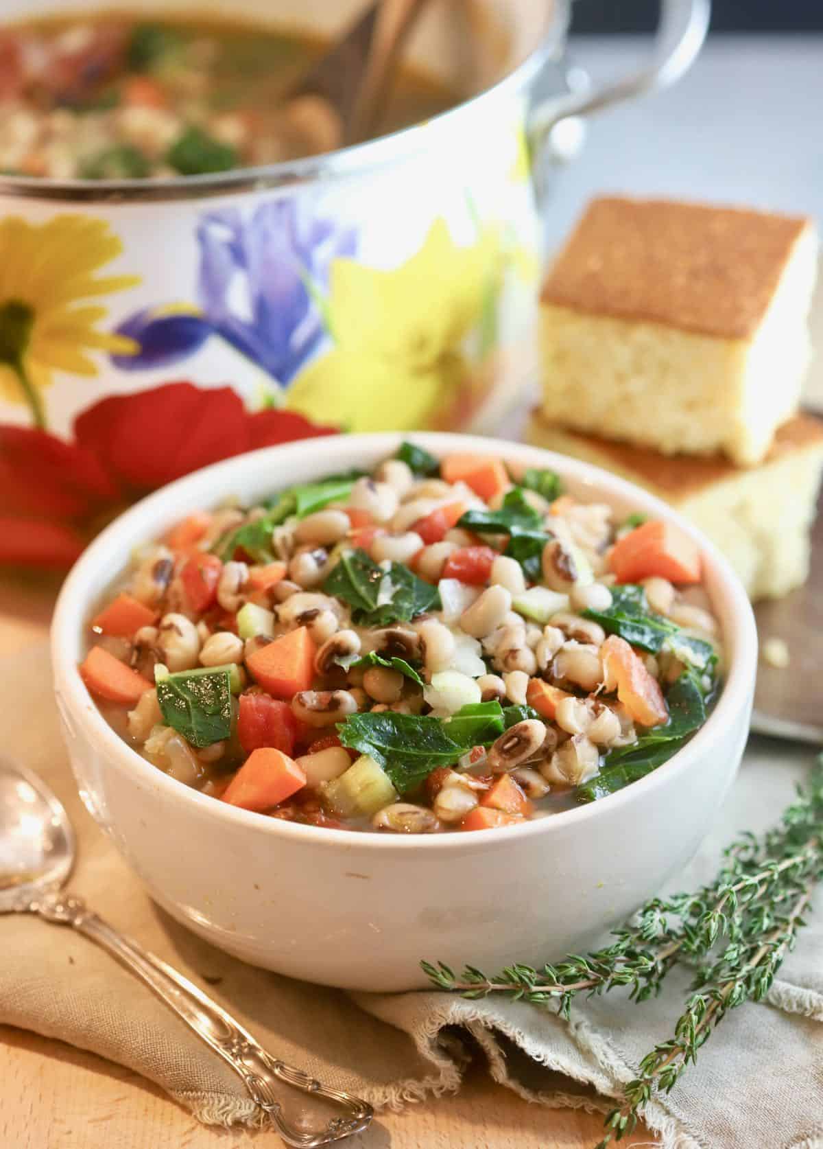 A bowl of black-eyed pea soup with cornbread. 