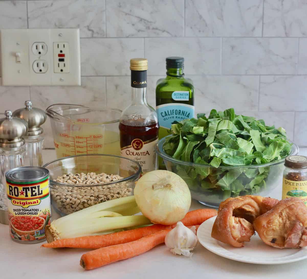 Ingredients for black-eyed pea soup including carrots, onions and collard greens. 