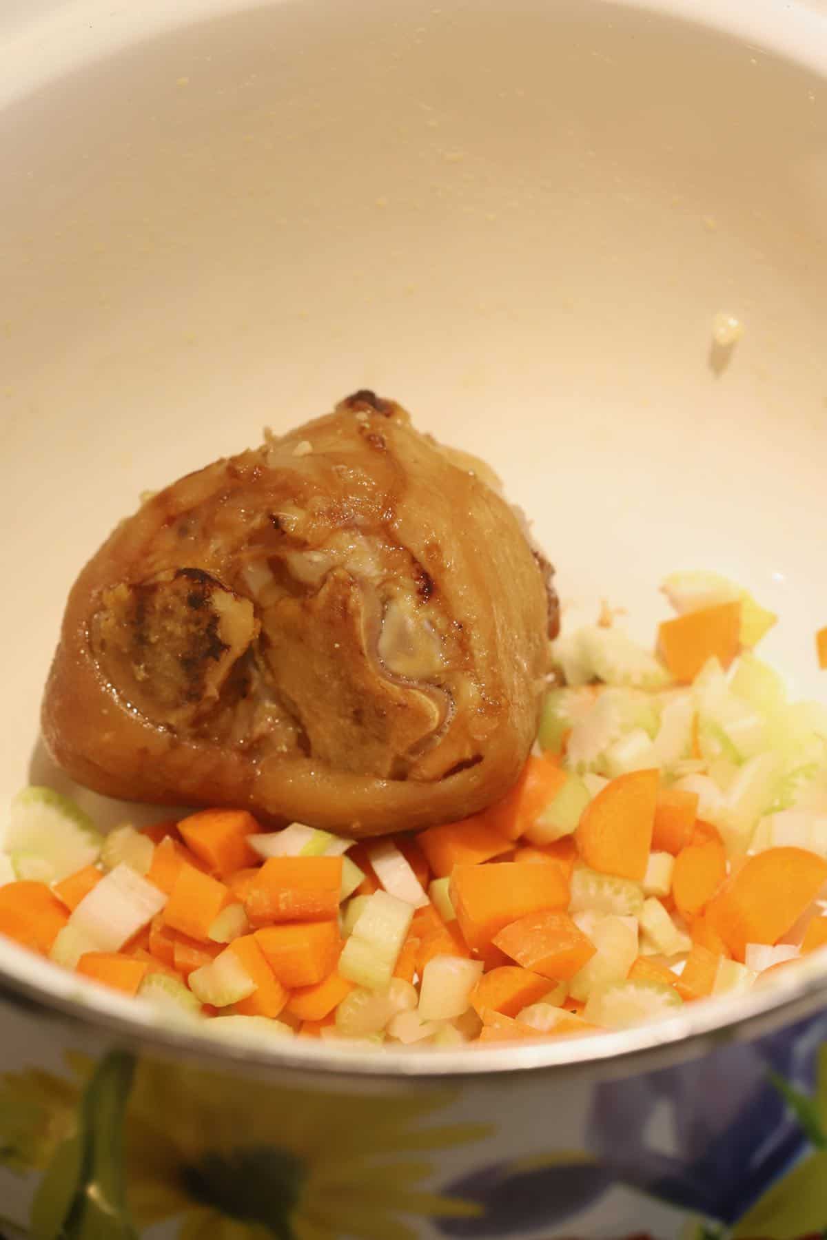 Carrots, onions, and celery cooking in a Dutch oven. 