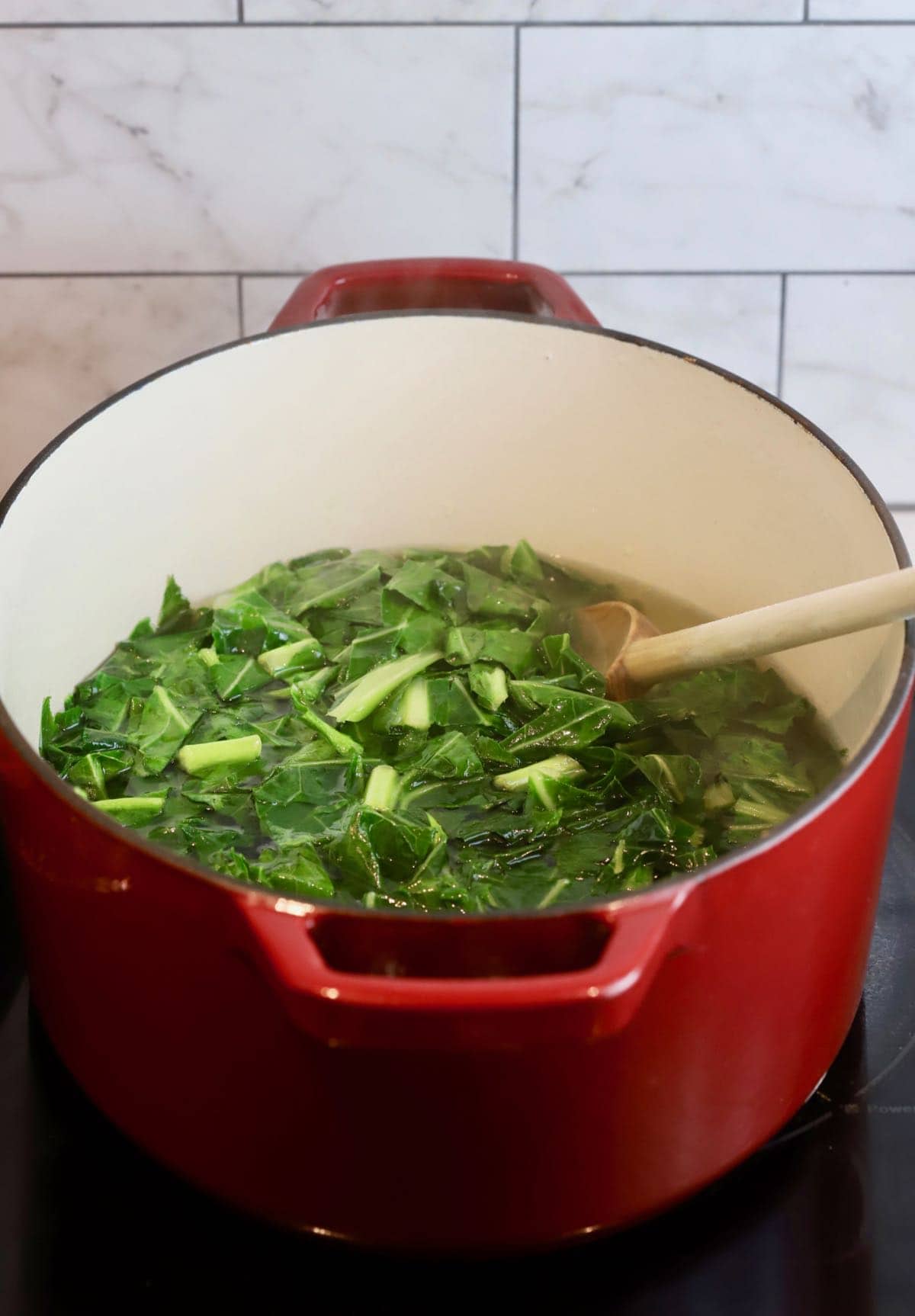 A Dutch oven with collard greens cooking. 