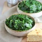 Two bowls of cooked collard greens.
