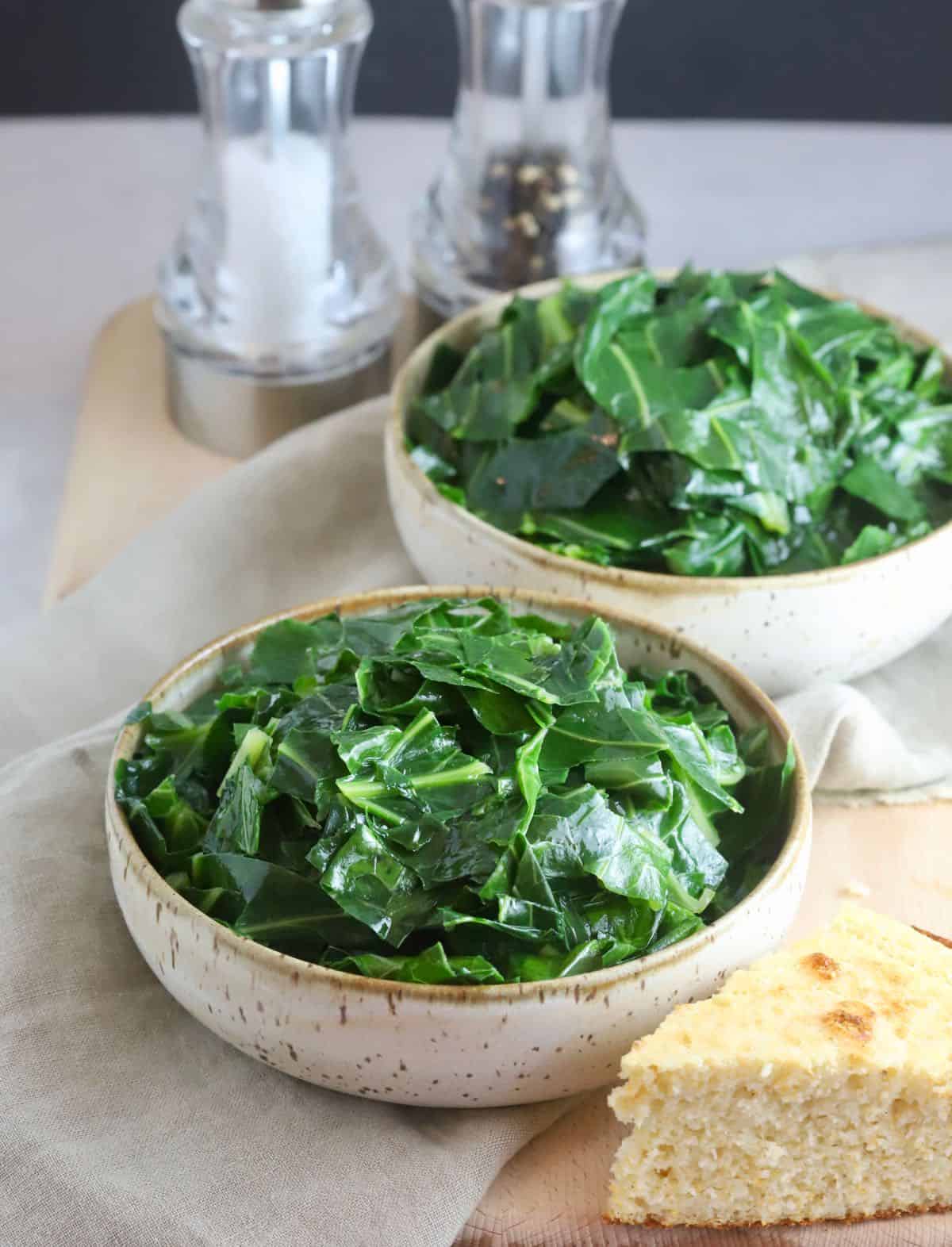 Two bowls of cooked collard greens.