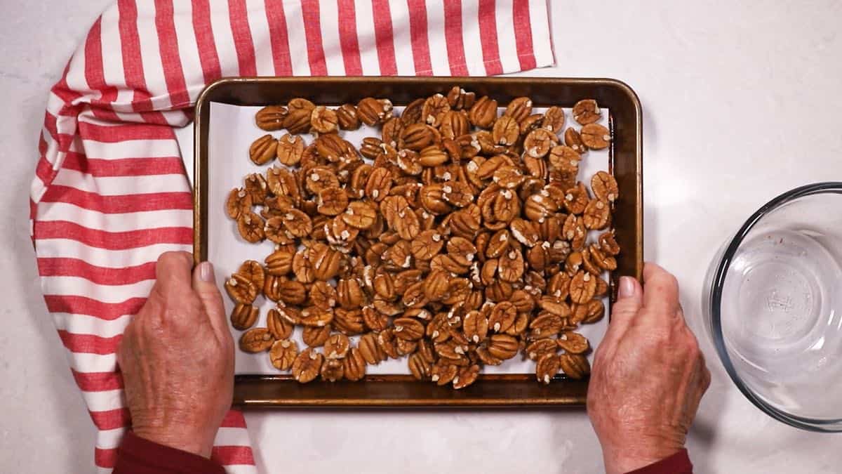 Pecan halves on a baking sheet.