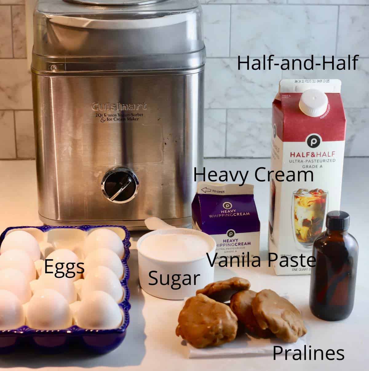 An ice cream maker and ingredients on a kitchen counter. 