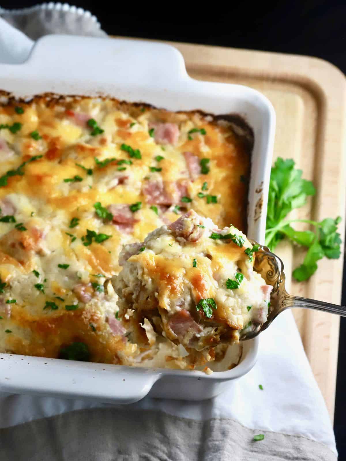 A spoonful of au gratin potatoes and ham. 