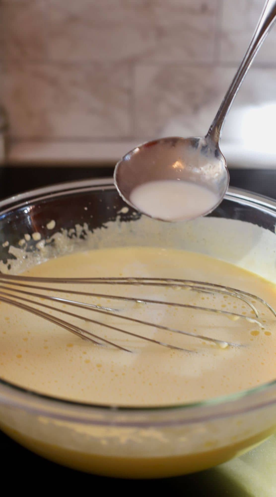 Tempering eggs by adding hot cream. 