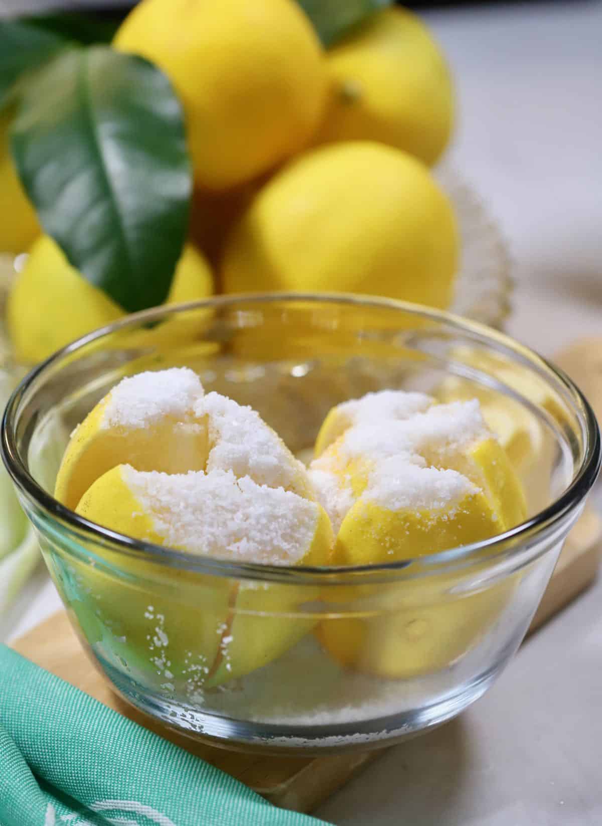 A bowl of lemons with salt on them. 