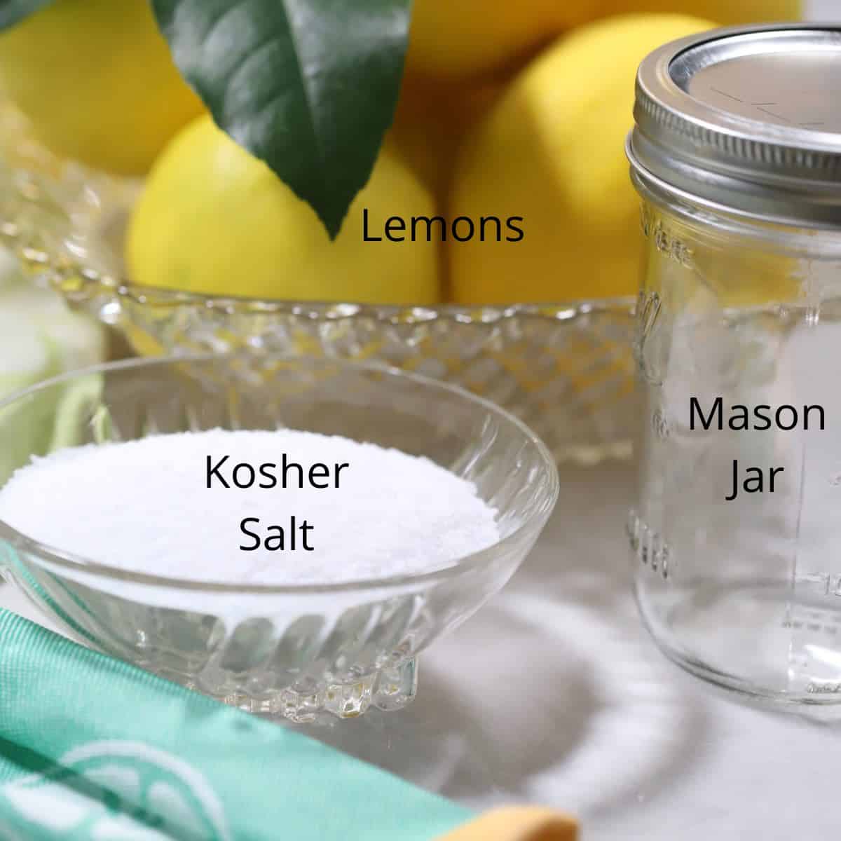 A bowl of kosher salt, lemons and a mason jar. 