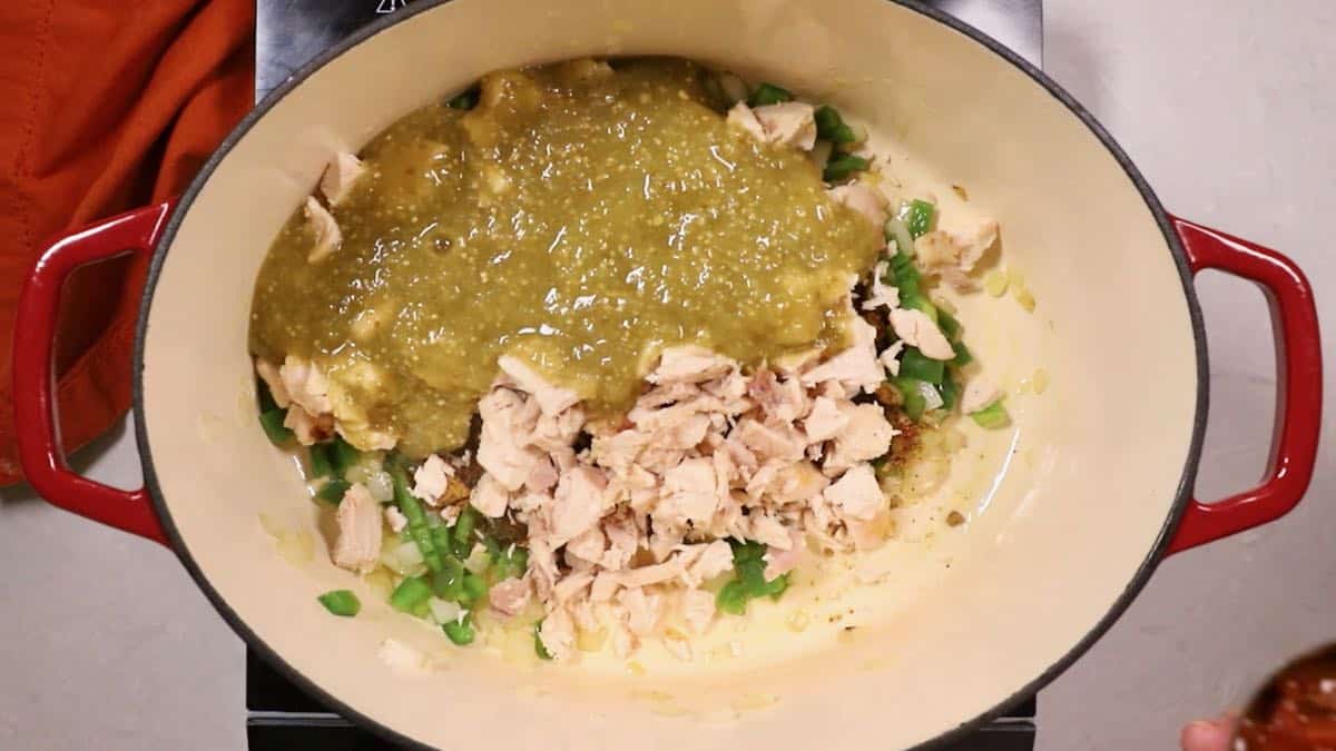 Chicken, bell pepper, and salsa verde in a Dutch oven.