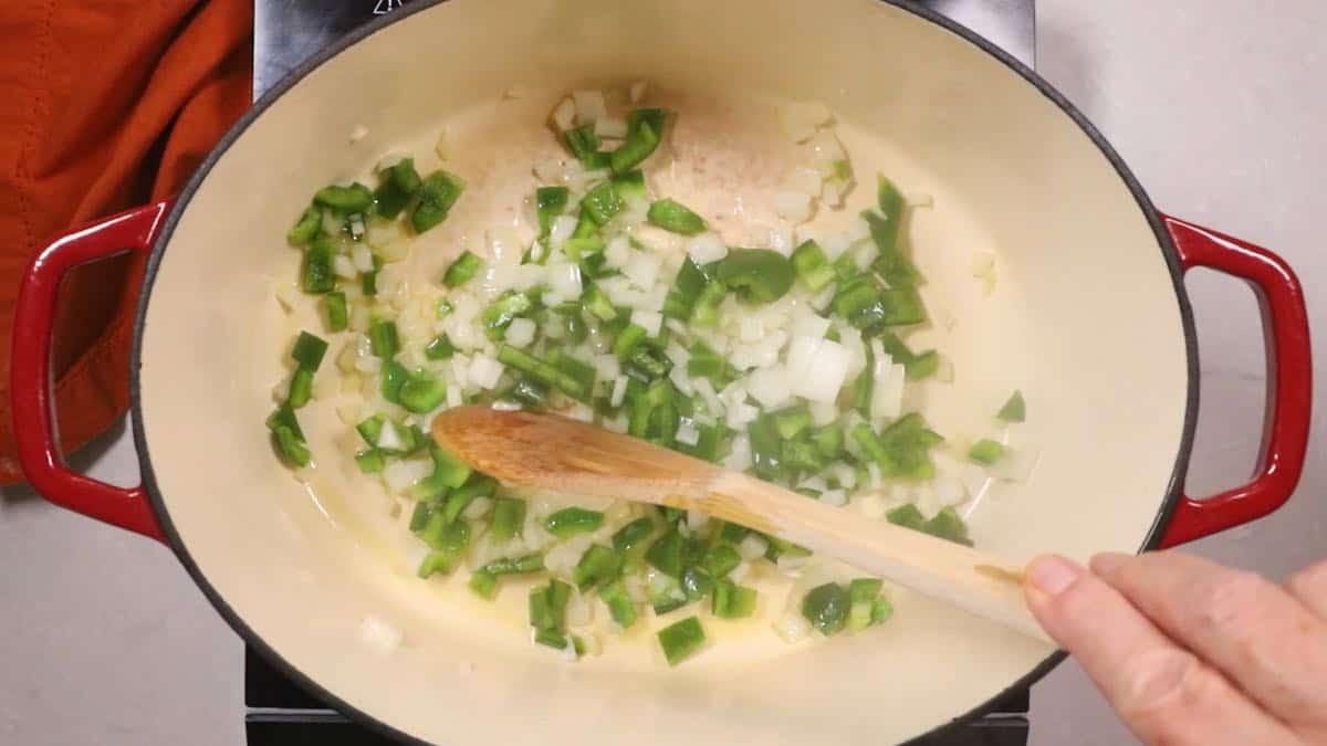 Cooking onion and bell pepper in a Dutch oven.