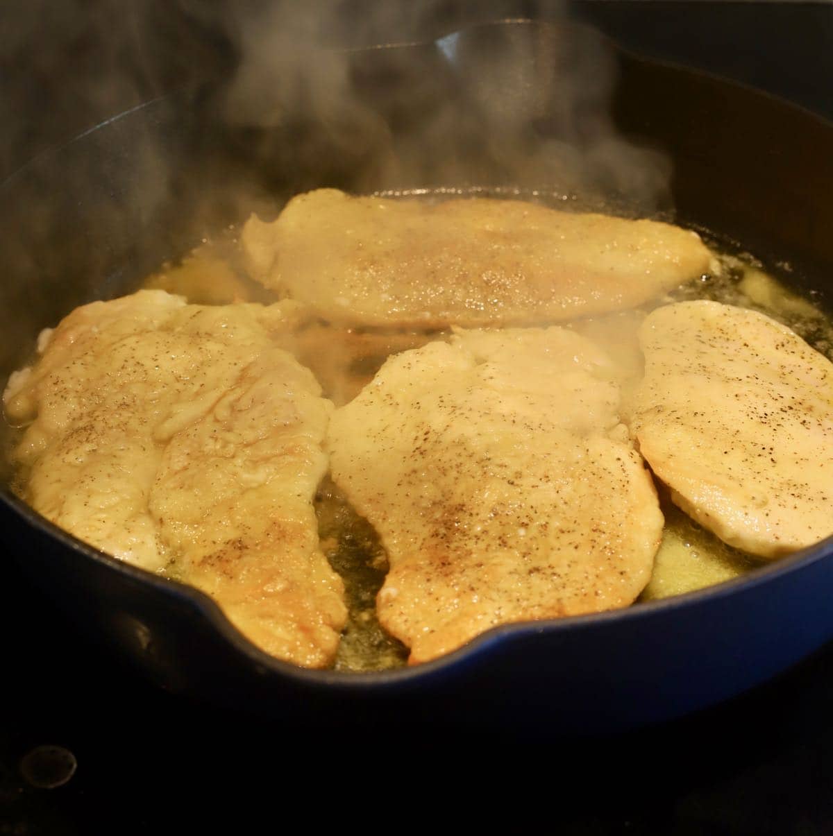 Cooking chicken cutlets in a skillet.