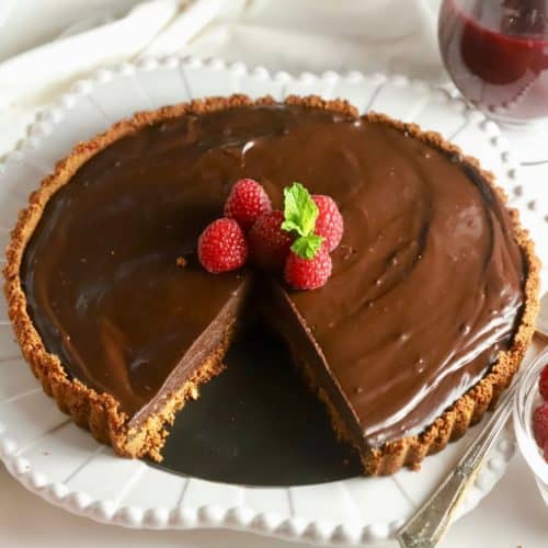 Chocolate Ganache Tart with a slice cut out.