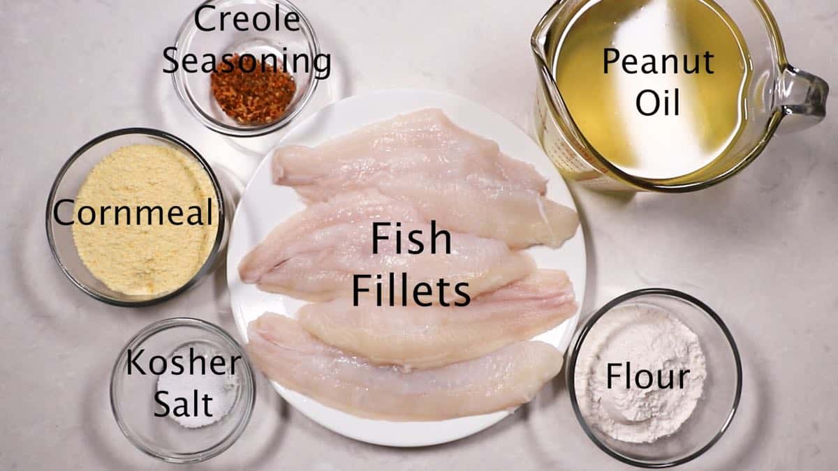 Ingredients for fried fish including fish fillets, and cornmeal. 