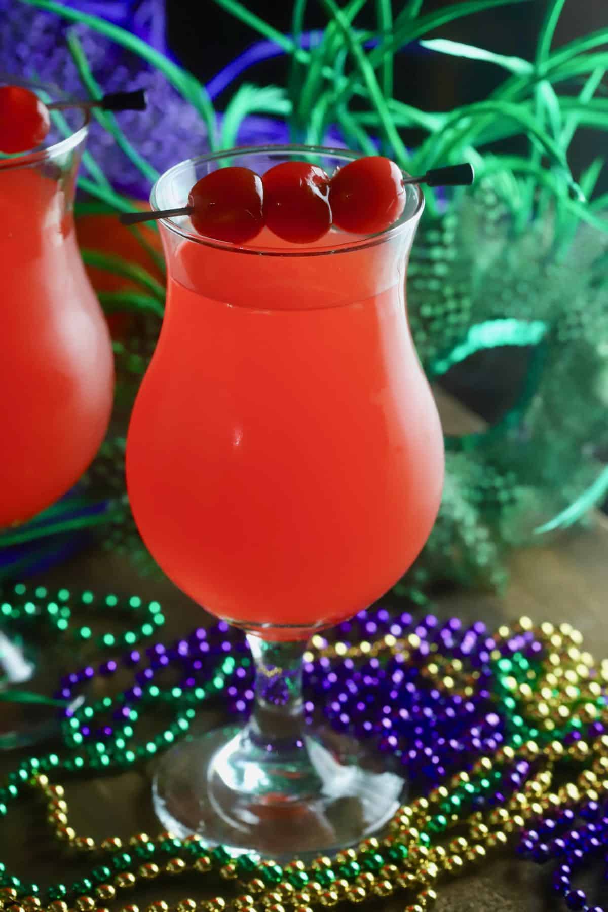 A hurricane cocktail garnished with cherries. 