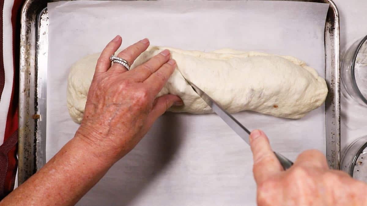 Cutting slits in a bread dough roll. 