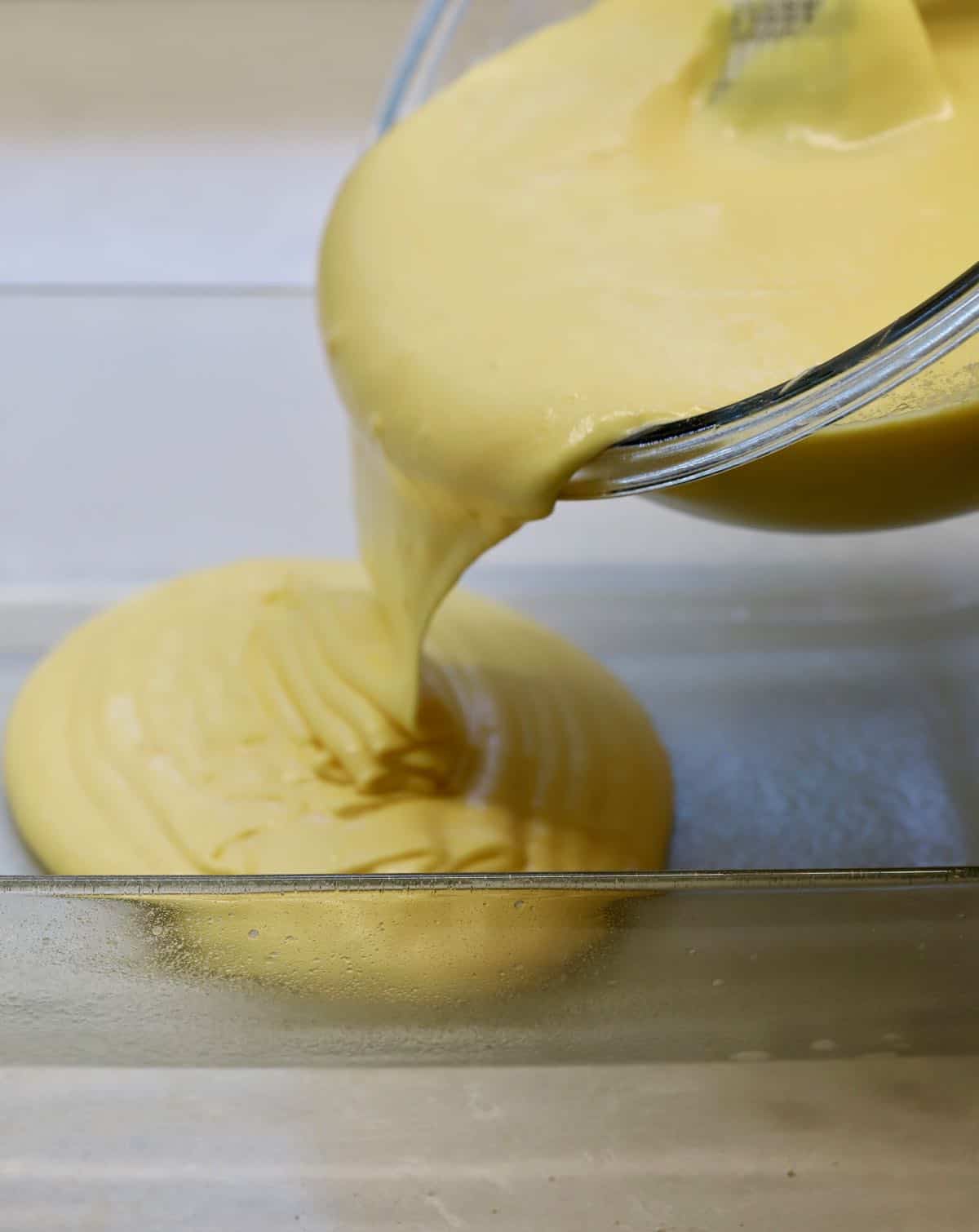 Pouring cake mix into a prepared cake pan. 