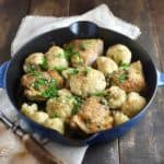 Chicken and cauliflower in a blue cast iron skillet.