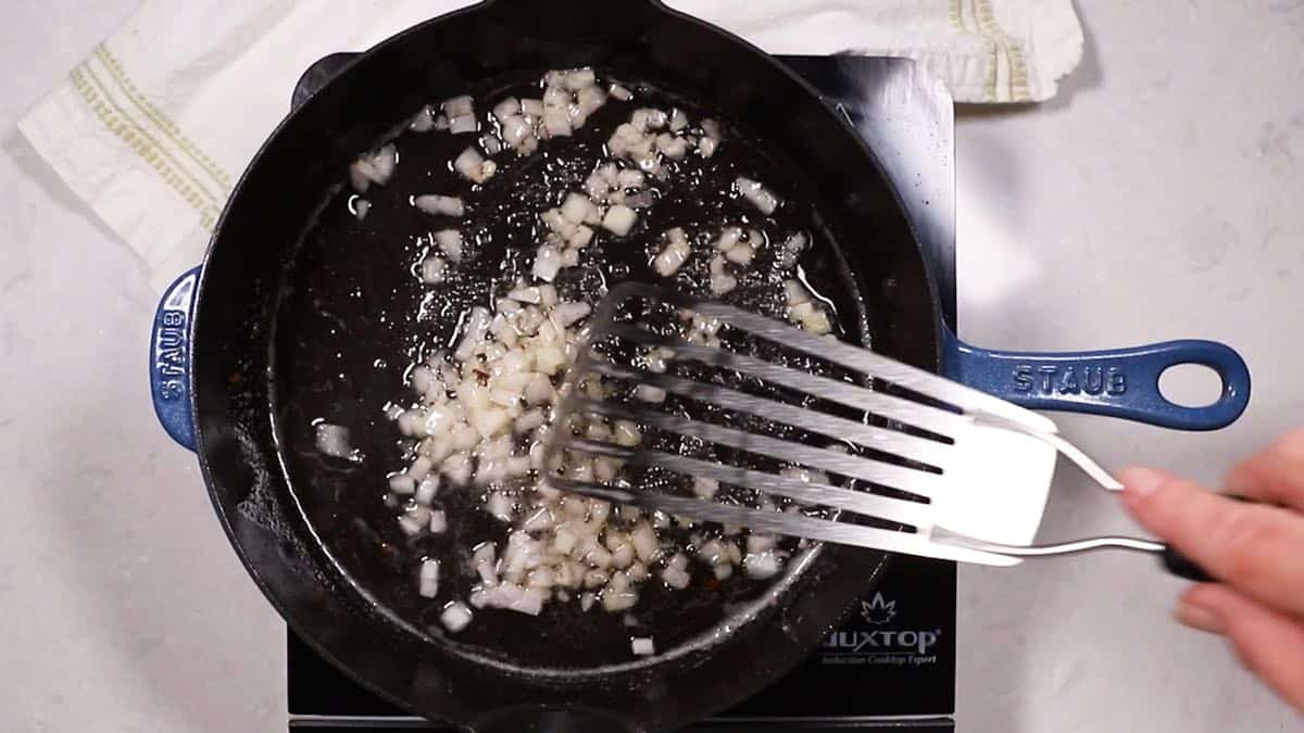 Cooking onion in a cast iron skillet.