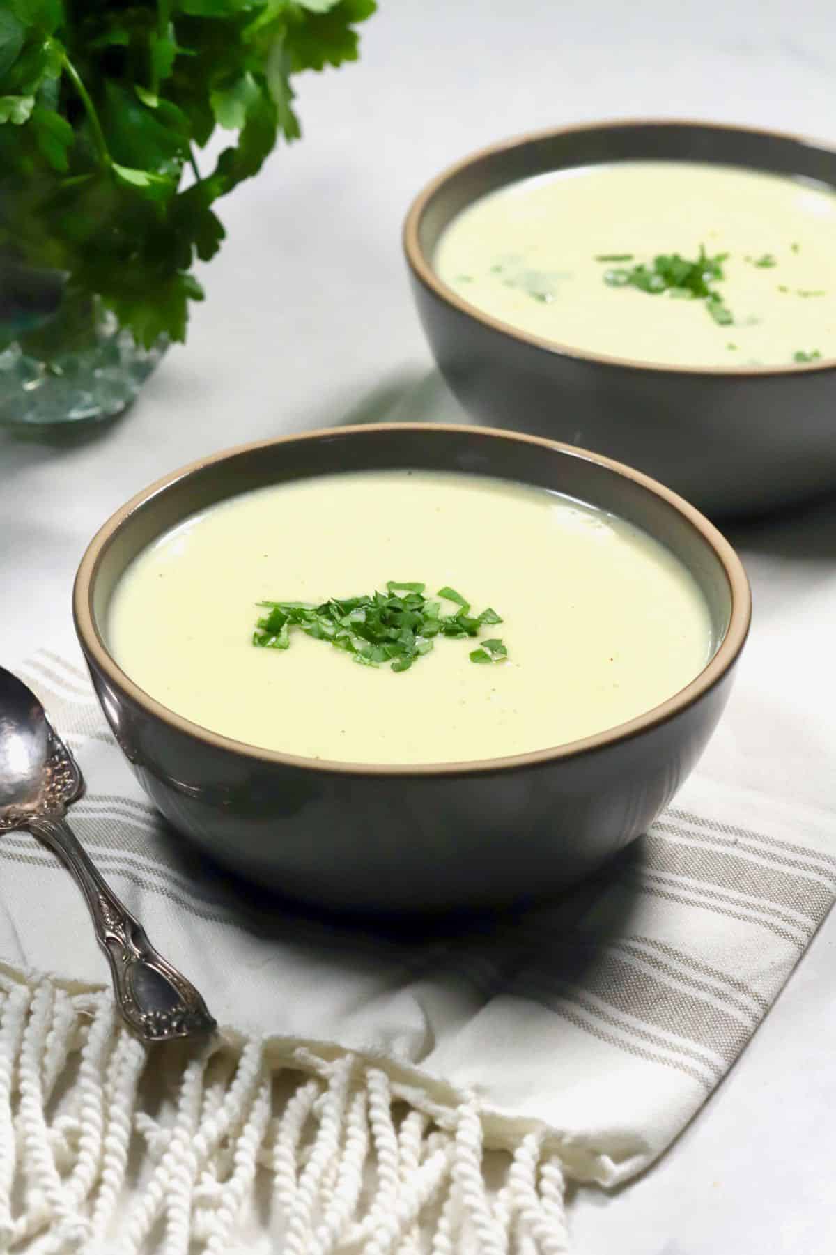Two bowls of Irish Potato Soup garnished with parsley. 