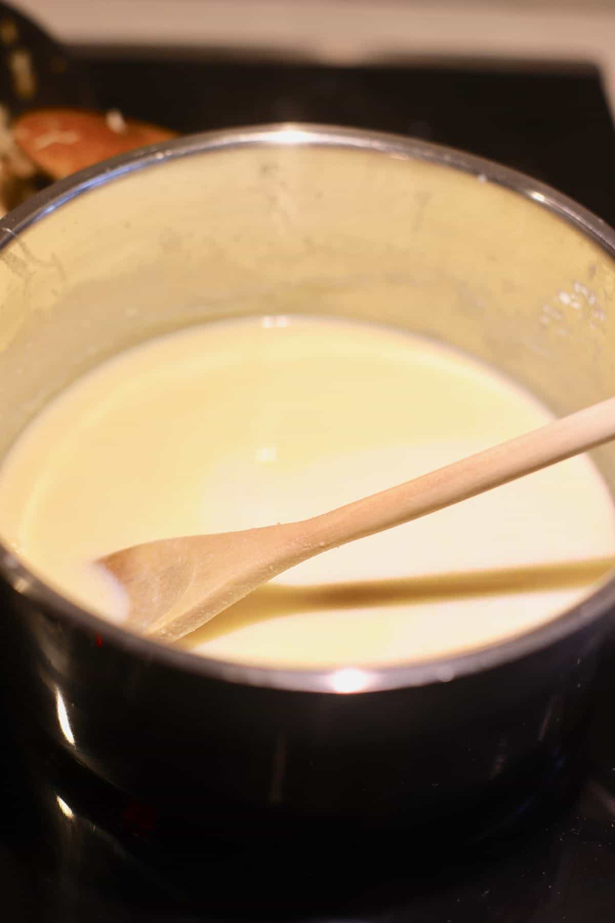 Mornay sauce in a saucepan on the stove.