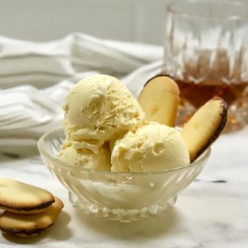 Three scoops of bourbon ice cream in a glass dessert dish.