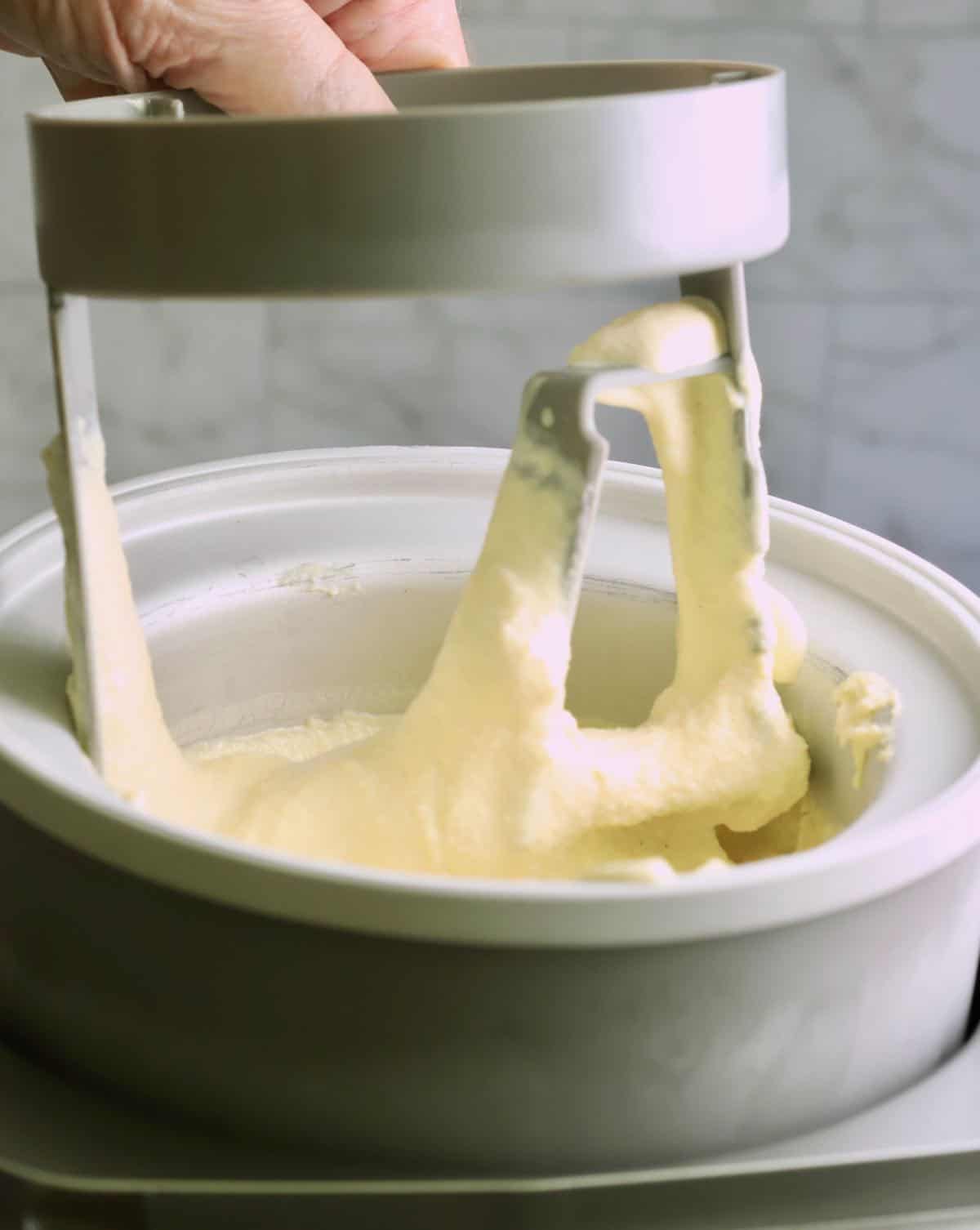 Removing frozen ice cream from an ice cream maker.