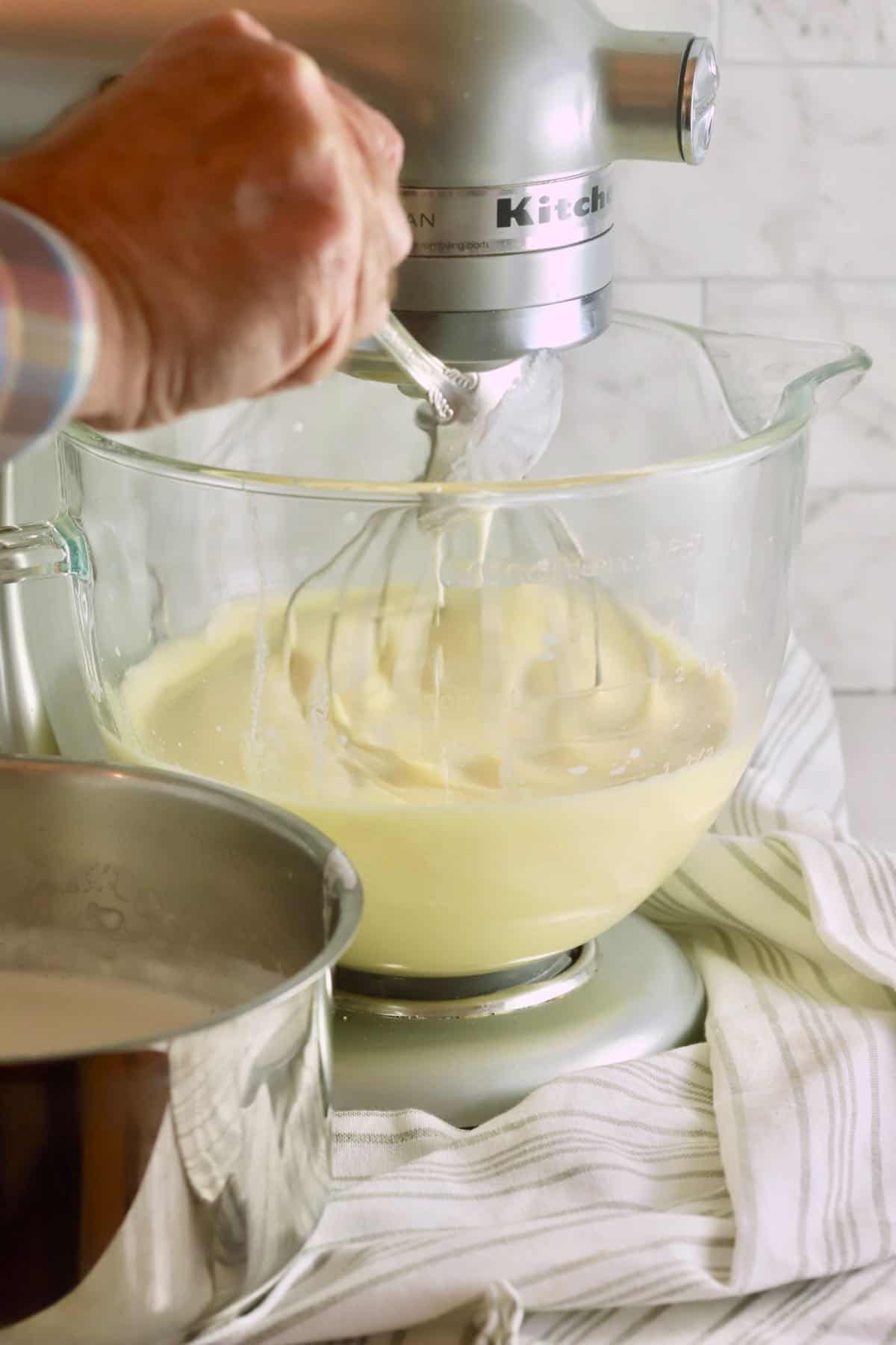 Tempering eggs by adding small amounts of hot cream.