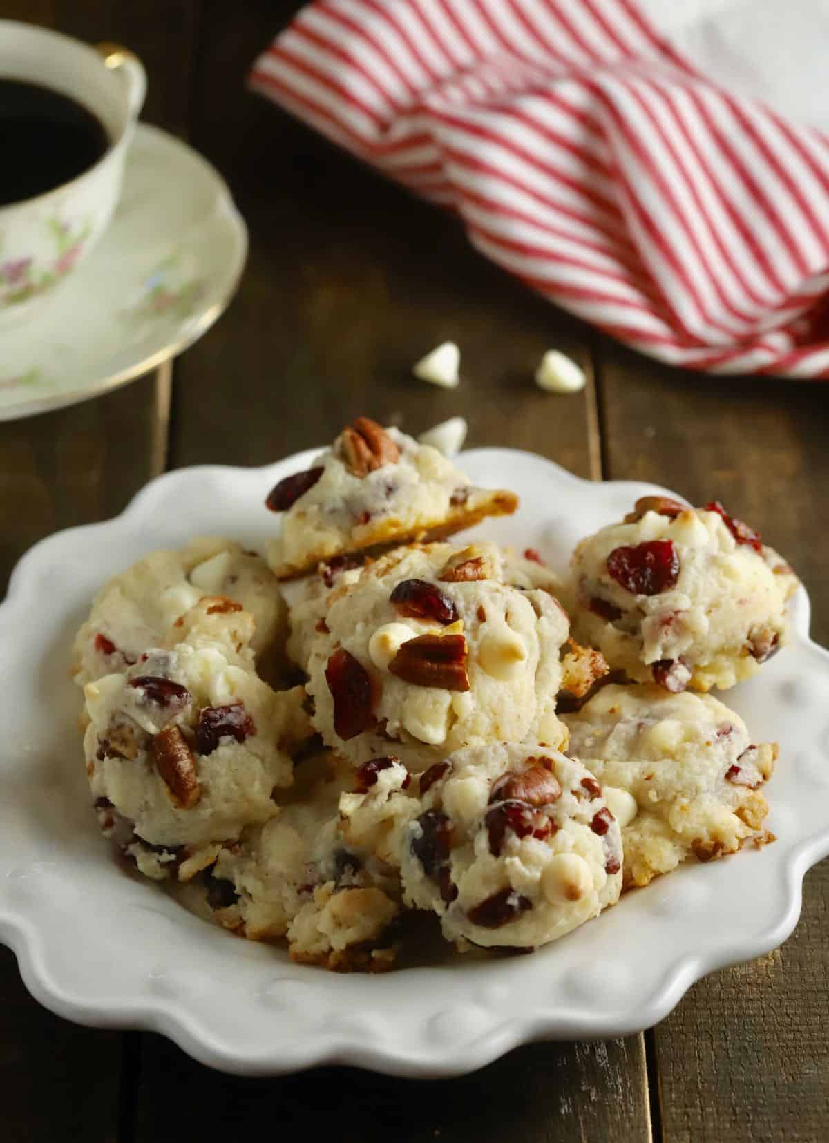 A plate of cranberry cookies next to a cup of coffee. 