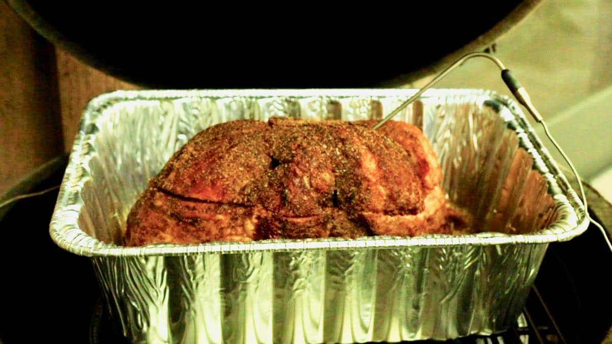 Temperature probe in a ham on a grill.