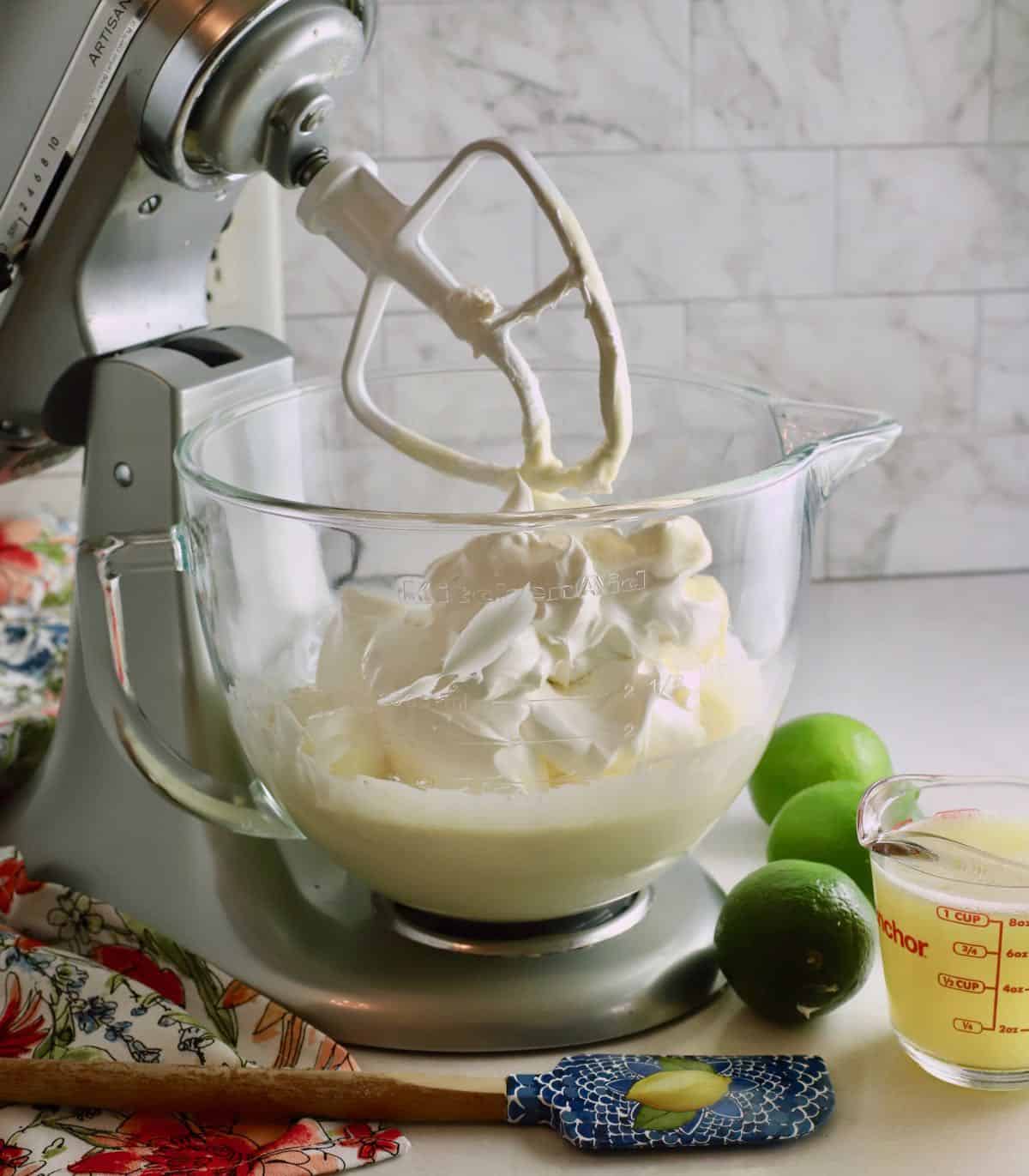 An electric mixer bowl full of cool whip and sweetened condensed milk. 