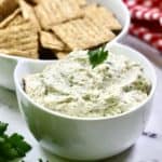 Chicken Ranch Dip in a white serving bowl with Triscuits.