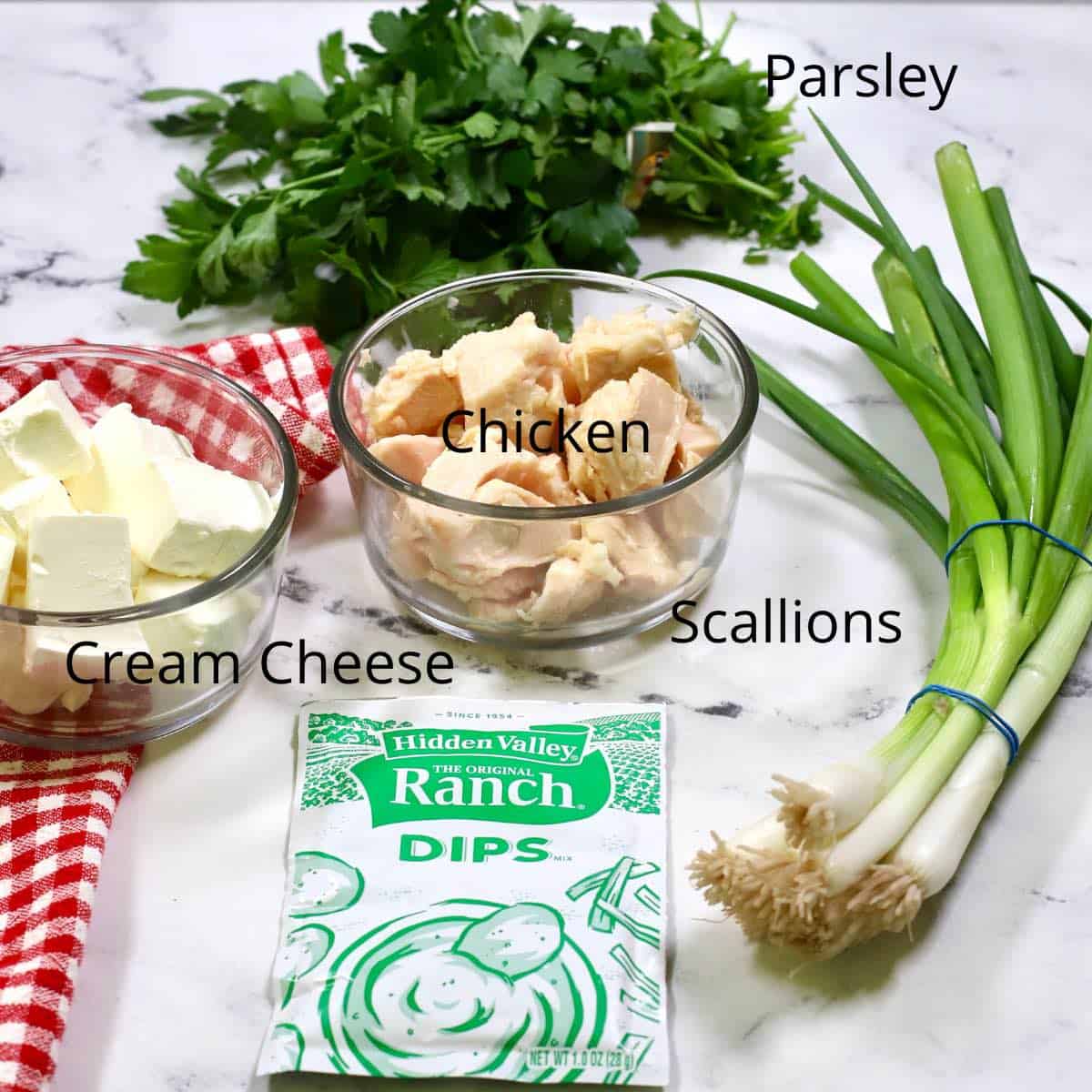 Ingredients for chicken ranch dip including cream cheese, scallions and chicken. 