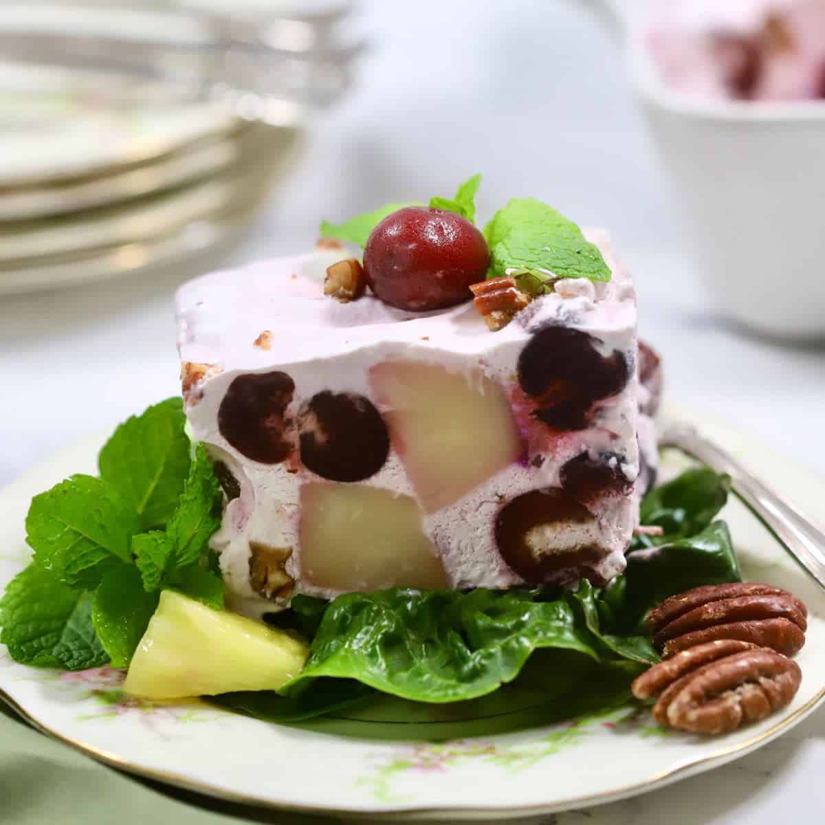 A square of frozen fruit salad on a plate.