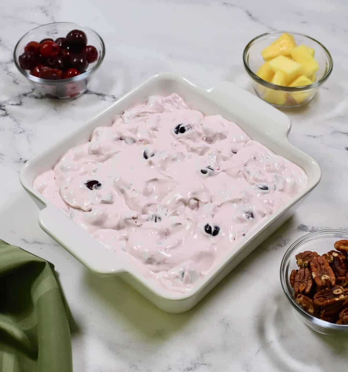 Frozen fruit dessert in a white square baking dish ready for the freezer.