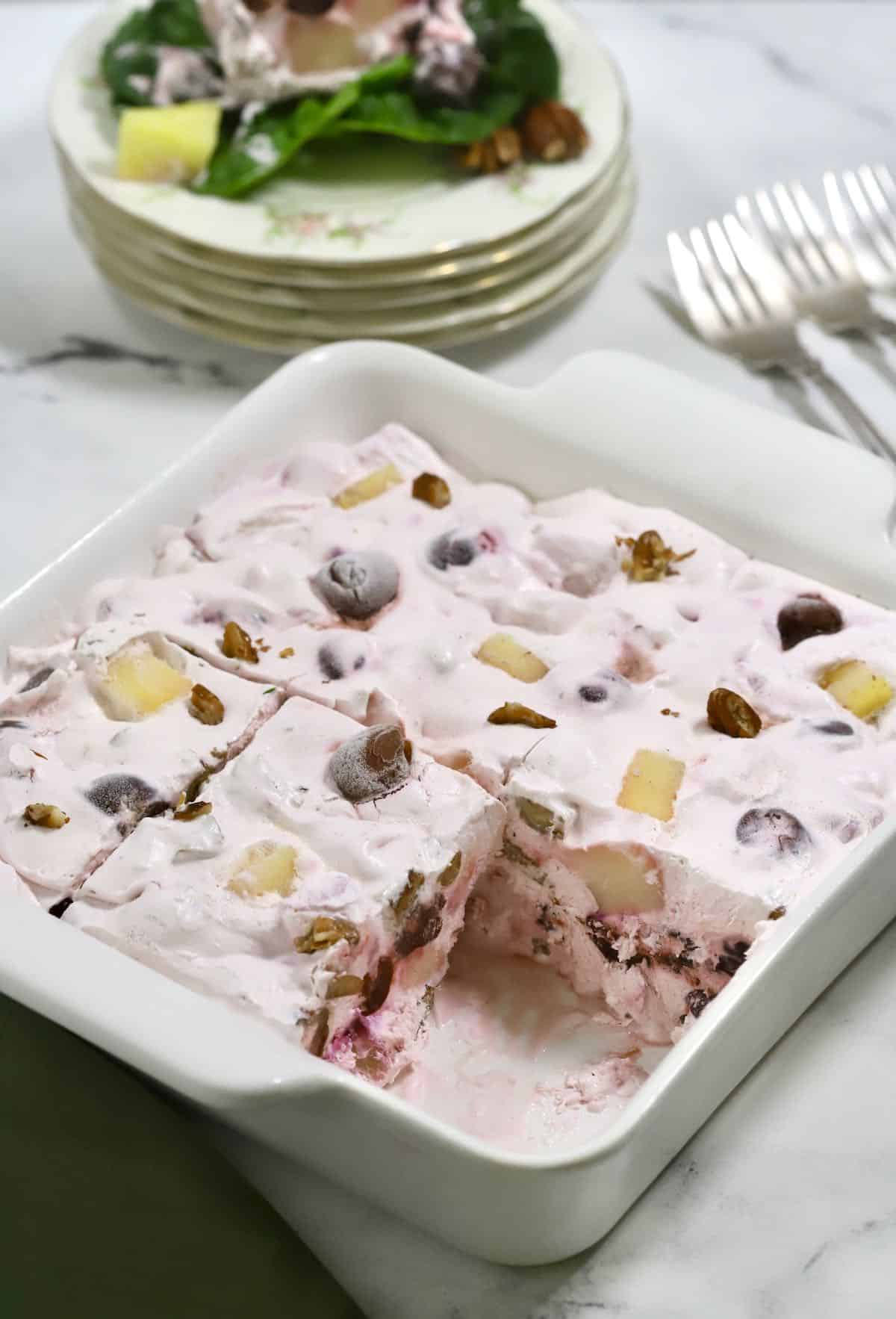 A white serving dish with frozen fruit salad.