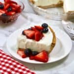 Frozen lemonade pie topped with macerated strawberries and blueberries.