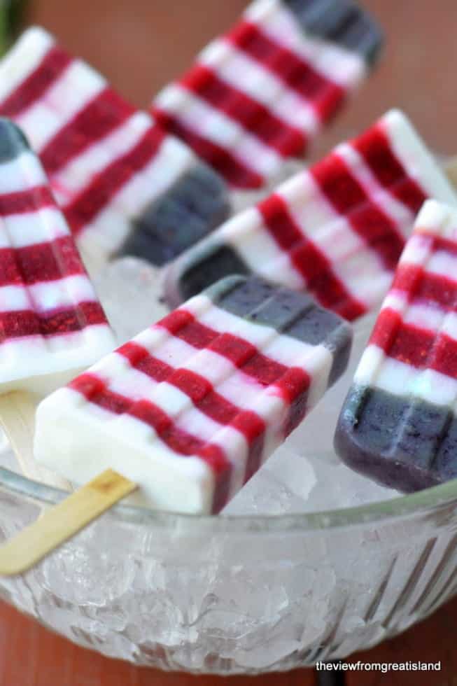 Red white and blue yogurt popsicles on a bed of ice. 