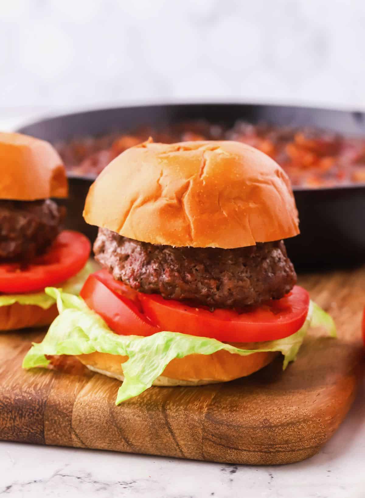 A hamburger on a bun with lettuce and tomato.