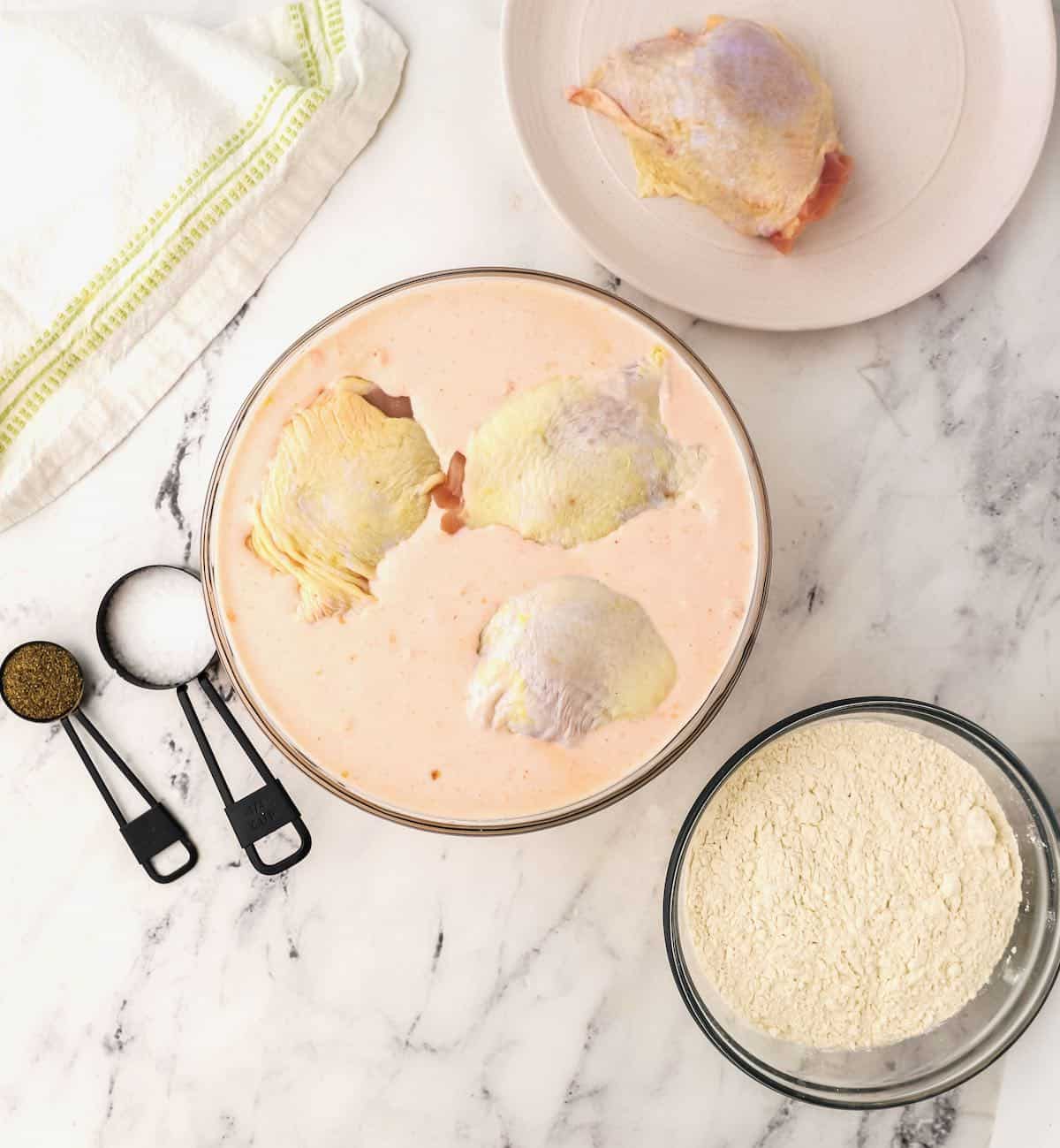 Chicken pieces marinating in buttermilk. 