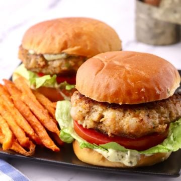 Two shrimp burgers with sweet potato fries.