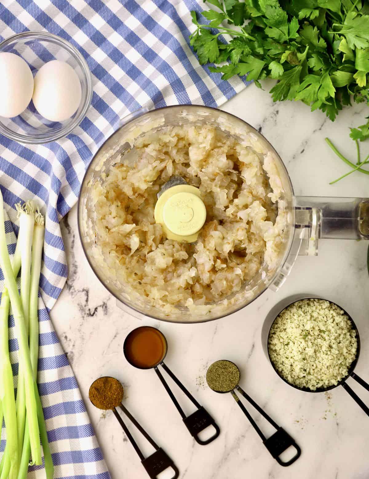 A food processor with chopped raw shrimp. 